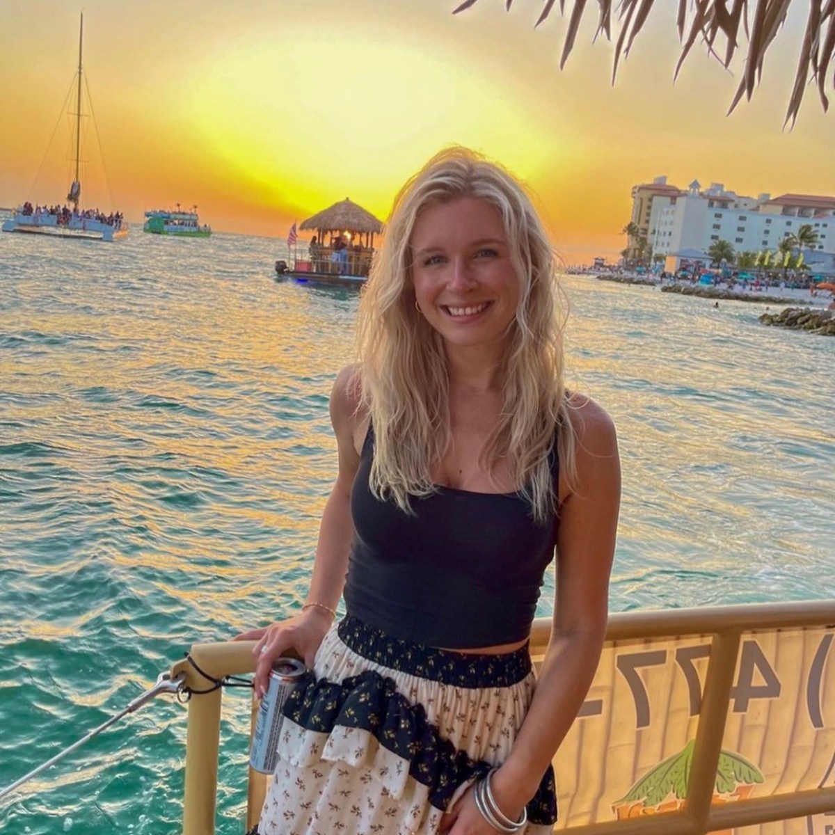 a woman standing in front of a body of water